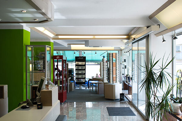 Modernes Optikerfachgeschäft mit Brillenregalen, Beratungstheke und heller Glasfront.